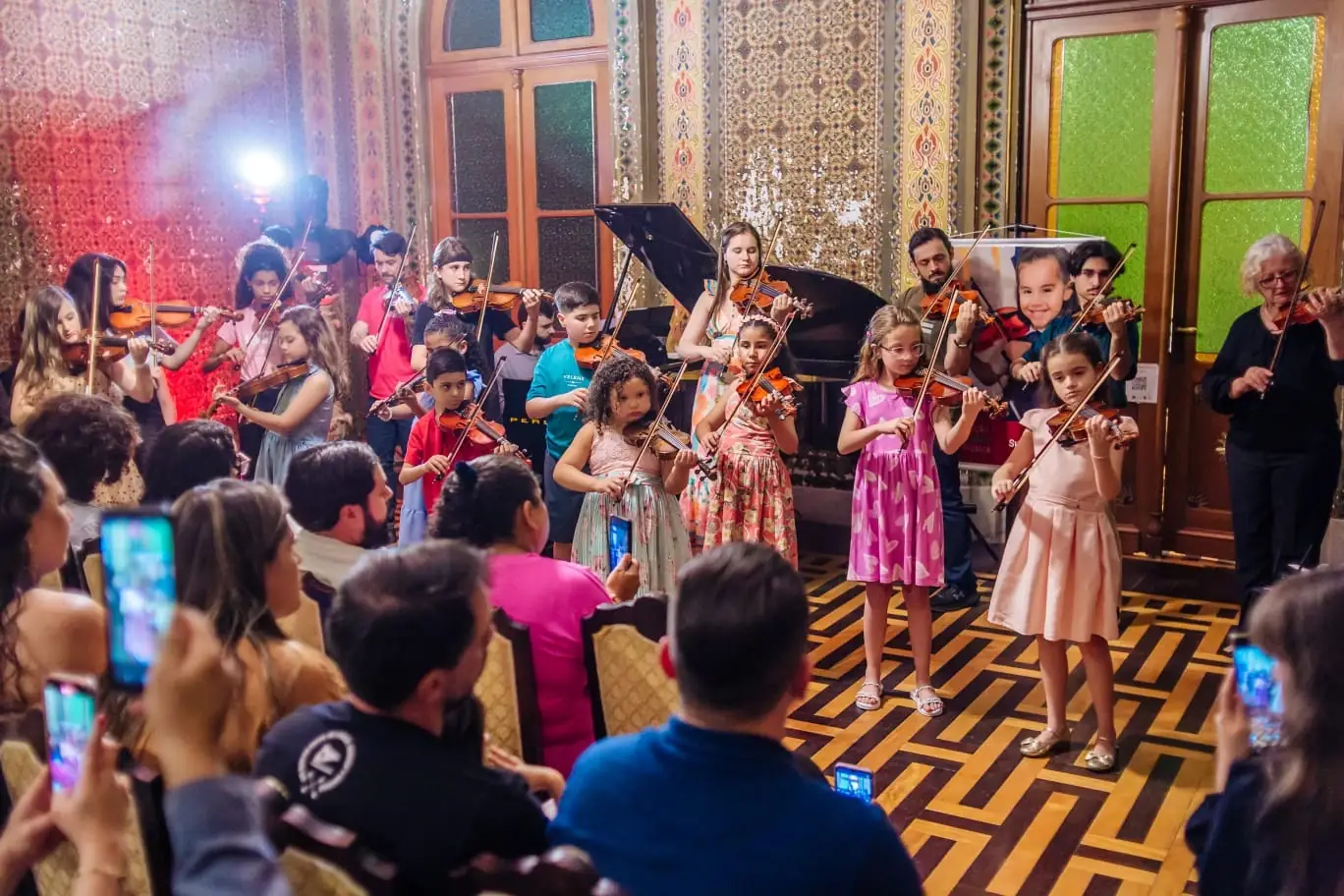 Alunos do Centro Suzuki Gaúcho tocando violino em recital em salão histórico